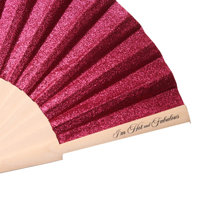 Close-up of a pink glittery product with 'I'm Hot and Fabulous' text on a beige background