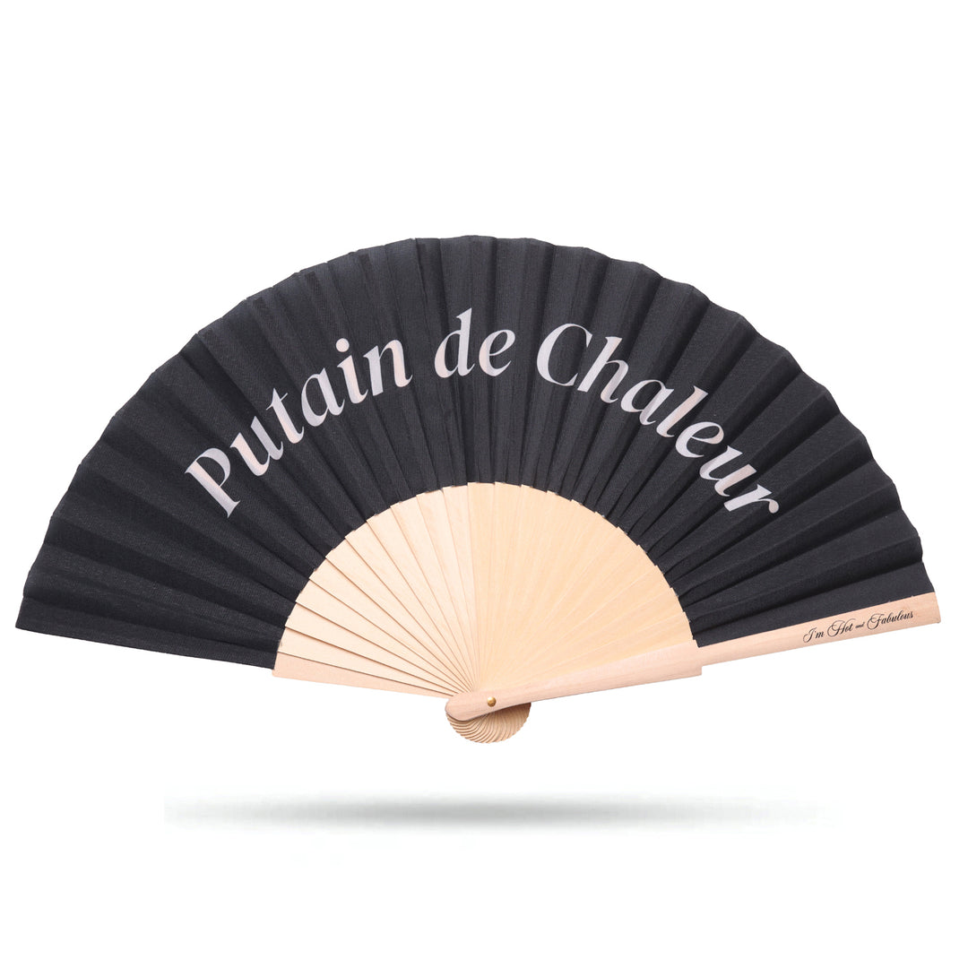 Black hand fan with beige sticks and 'Putain de Chaleur' text on a white background