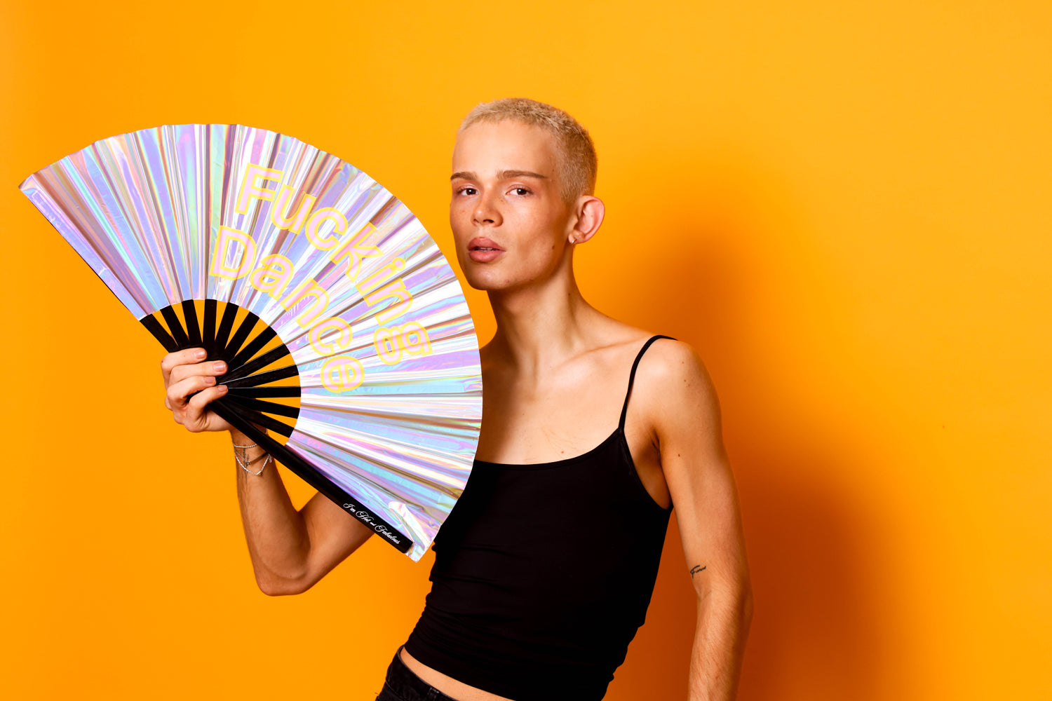 Person holding a colorful fan against an orange background