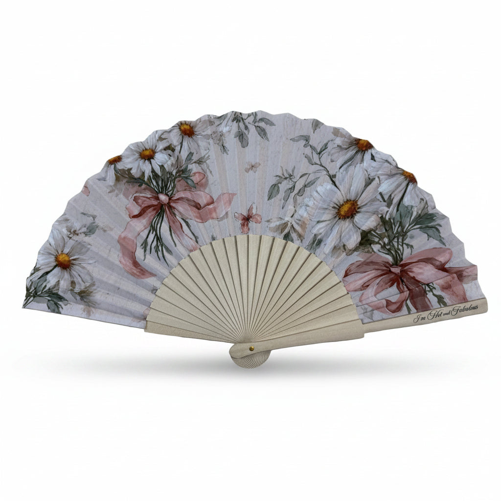 Floral-patterned hand fan on a wooden surface