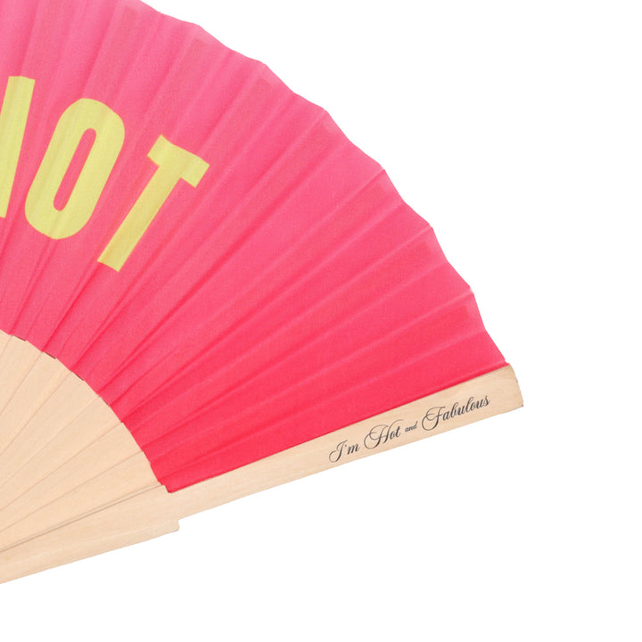 Pink hand fan with yellow text and wooden handle on a white background
