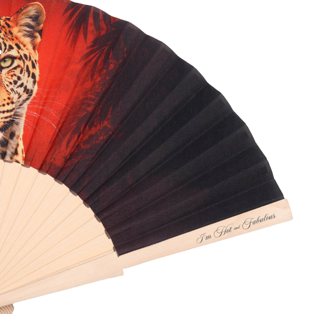 Hand fan with a leopard design on a red background
