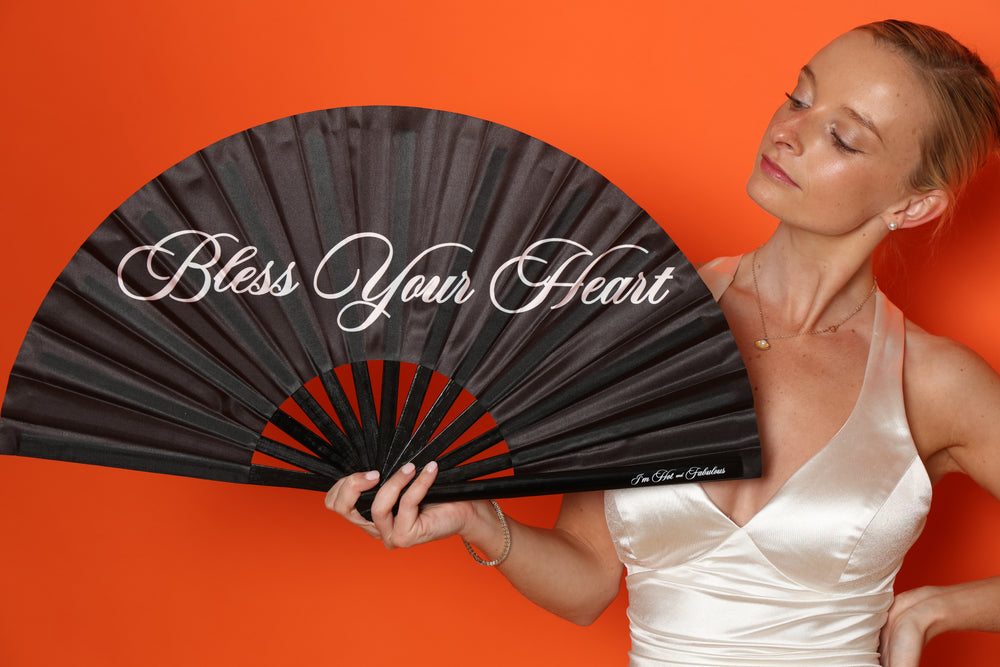 woman with a hand fan that says bless your heart
