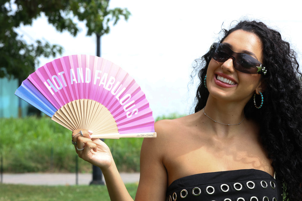 Woman holding a colorful fan with 'HOT AND FABULOUS' text.
