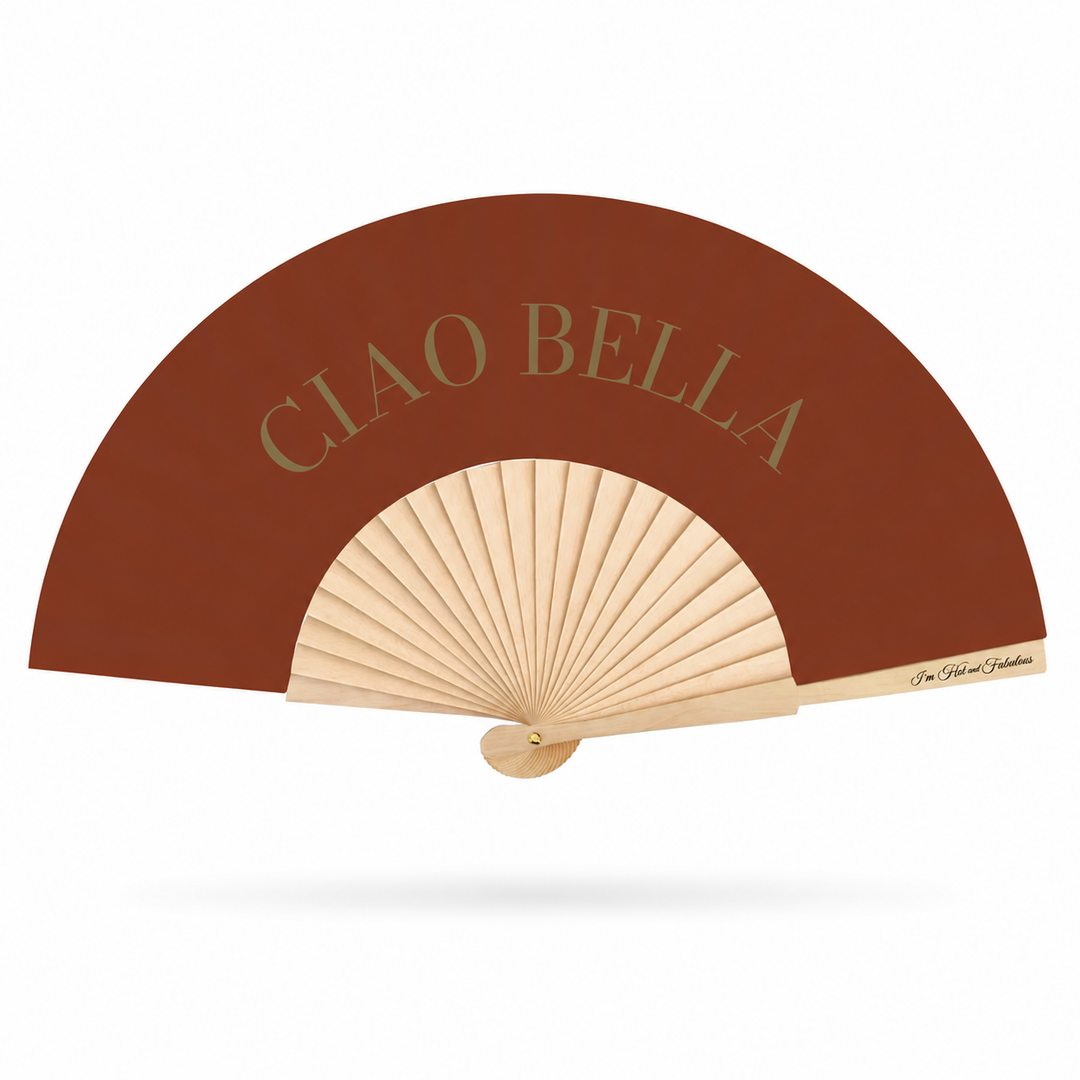 A folding hand fan with a warm brown outer panel and natural beige ribs, featuring the text 'CIAO BELLA' in gold on the brown section and a small script logo on the side.