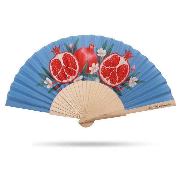 Handheld fan with pomegranate design on a blue background