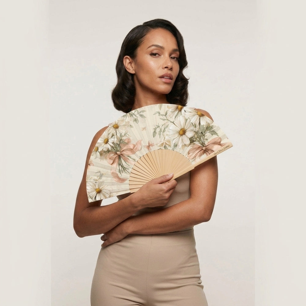 Woman holding a floral-patterned fan against a plain background
