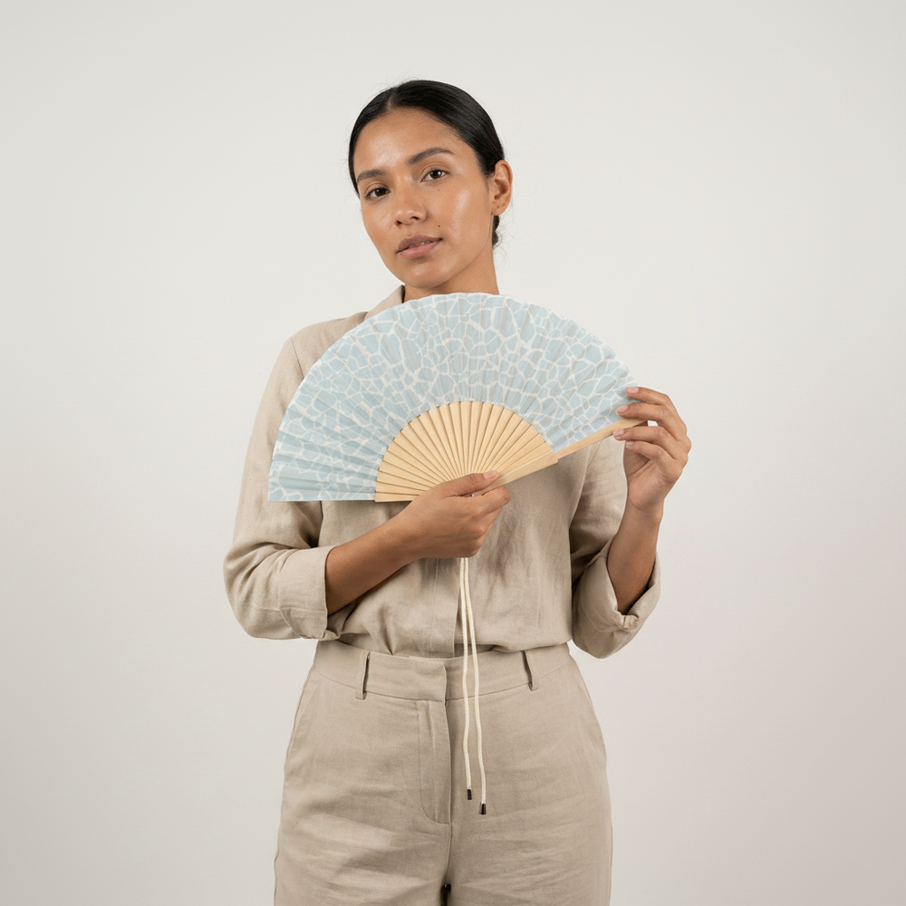 woman holding a blue ocean fan